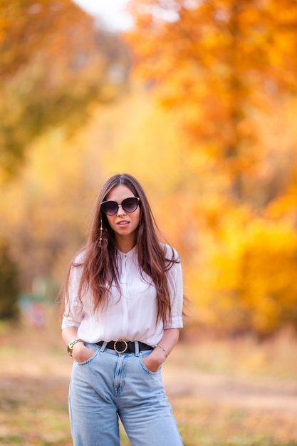 Concepto de otoño - hermosa mujer en otoño parque bajo follaje de otoño