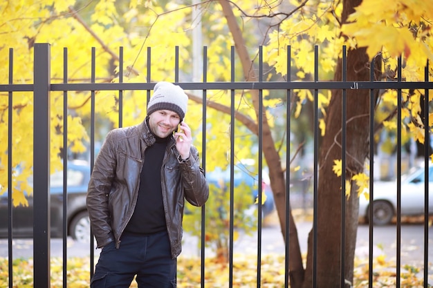 Concepto de otoño Un hombre camina por la ciudad Hojas de otoño en el sendero