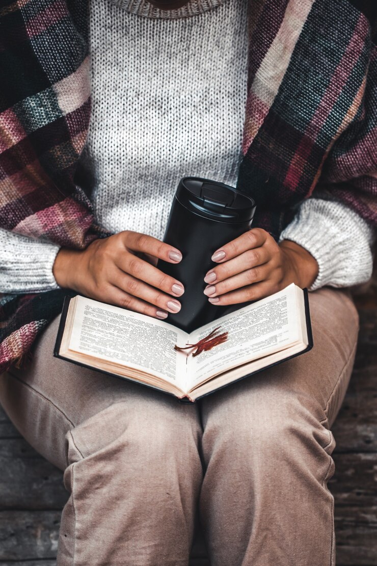 Foto concepto de otoño, un libro abierto en manos de una niña con hojas amarillas