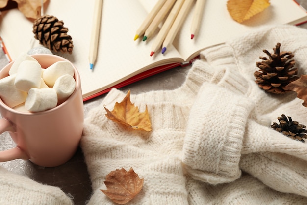 Concepto de otoño con suéter y café sobre fondo gris