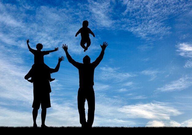 Concepto de padres homosexuales. Silueta de padres gays felices con niños en el fondo del cielo