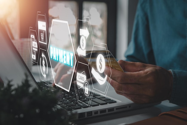 Concepto de pago Empresario que utiliza una computadora portátil y una tarjeta de crédito en el escritorio de la oficina con el icono de pago en la pantalla virtual