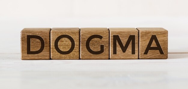 Concepto de palabra DOGMA escrito en cubos de madera
