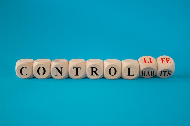 Foto concepto palabras rojas hábitos de control para controlar la vida en hermosos cubos de madera hermoso fondo azul