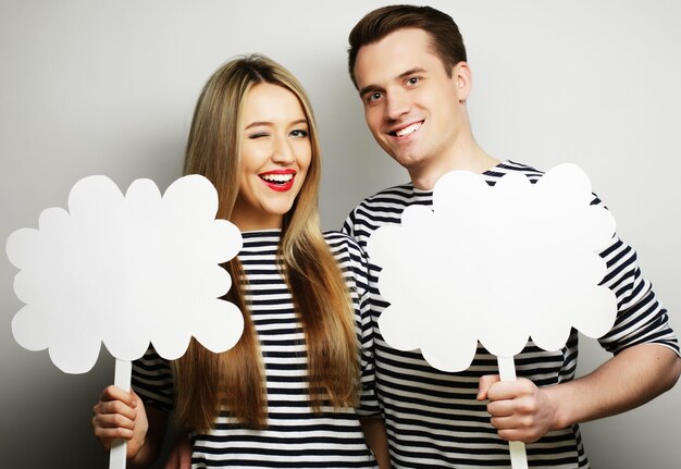 Concepto de pareja, amor y familia: pareja amorosa sosteniendo papel en blanco en el palillo.