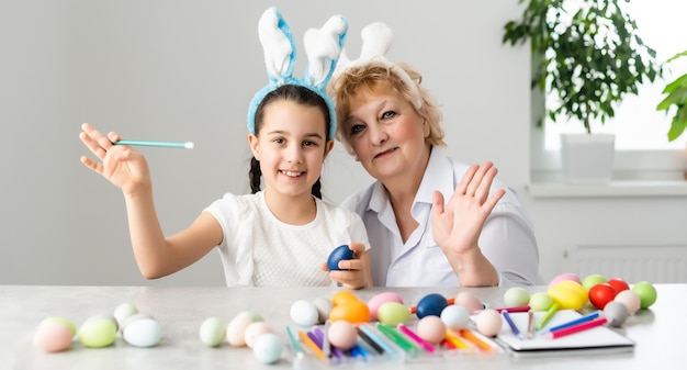 Concepto de Pascua. Abuela con nieta tiene huevos de Pascua en casa.