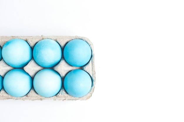 Concepto de Pascua feliz. Huevos de gallina pintados de color azul en el compartimento para huevos.