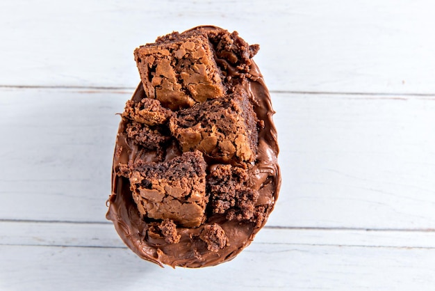 Concepto de Pascua Huevo de Pascua lleno de chocolate y brownie sobre fondo blanco.