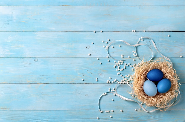 Concepto de pascua. Huevos de Ombre en colores azules sobre fondo de madera azul con espacio de copia de texto. Vista de arriba hacia abajo o plano. Colores azules clásicos en Semana Santa 2020