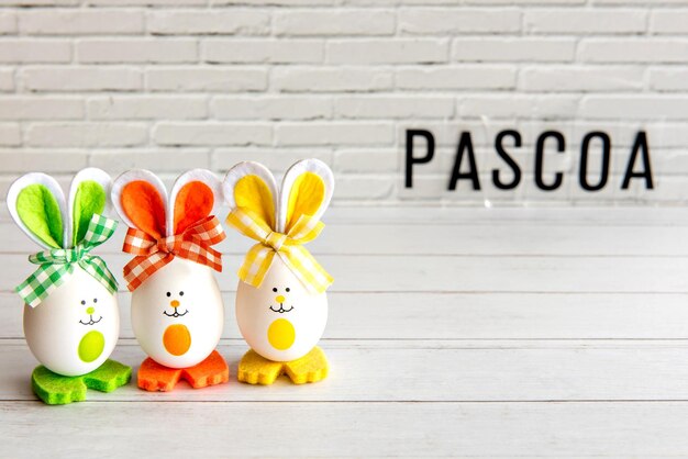 Concepto de pascua huevos de pascua decorados en fondo blanco con pascua escrita en portugués