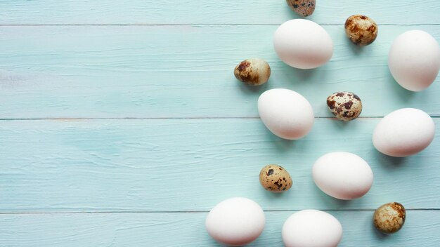 Concepto de Pascua con huevos de pollo y codorniz sobre fondo de madera