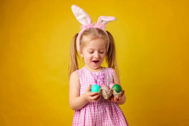 Concepto de pascua. Niña feliz rubia niño con orejas de conejo