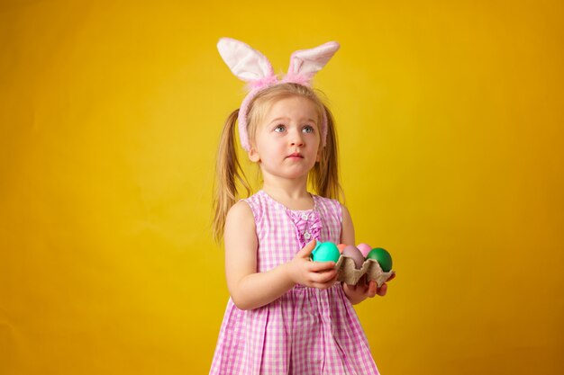 Concepto de pascua. Niña feliz rubia niño con orejas de conejo