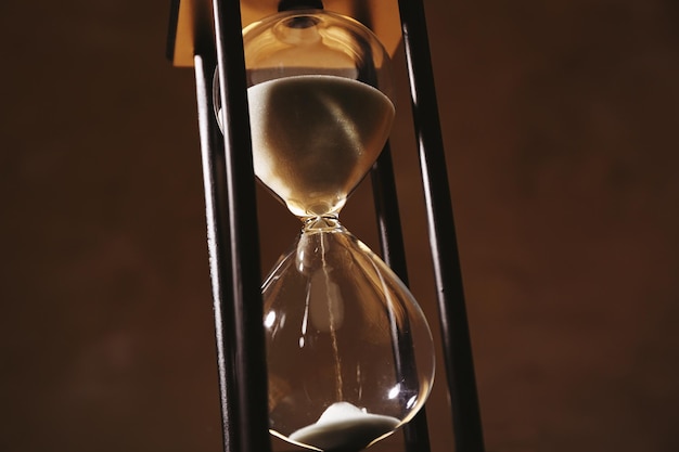 Concepto de paso del tiempo Reloj de arena negro con arena blanca sobre fondo oscuro