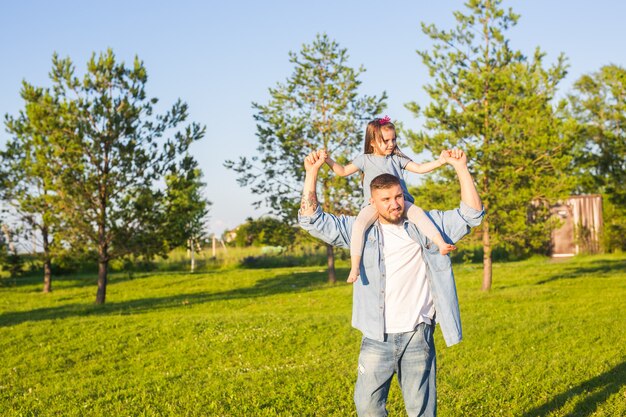 Concepto de paternidad, familia e hijos: padre e hija divirtiéndose y jugando en la naturaleza.