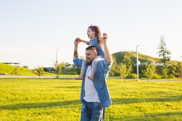 Concepto de paternidad, familia e hijos: padre e hija divirtiéndose y jugando en la naturaleza.