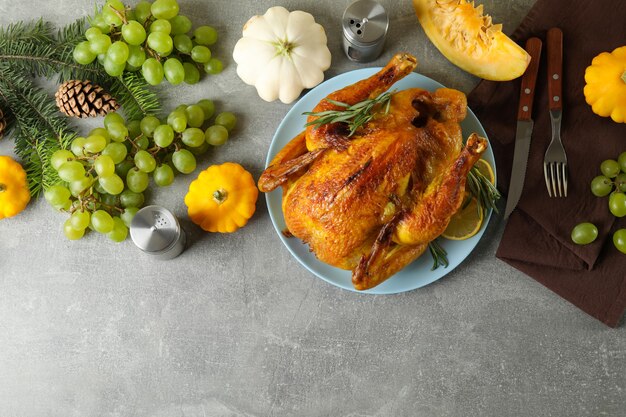 Concepto de pavo asado del día de acción de gracias en la mesa con textura gris