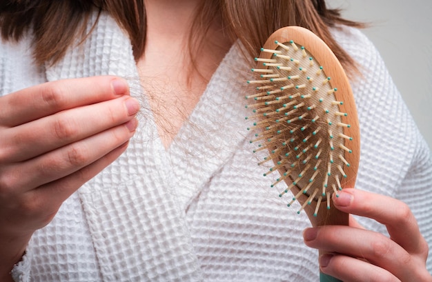 Foto concepto de pérdida de cabello cabello problema en peine aislado cabello dañado no saludable en primer plano de la mano