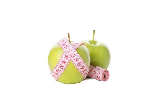 Concepto de pérdida de peso con manzana y cinta métrica aislado sobre fondo blanco.
