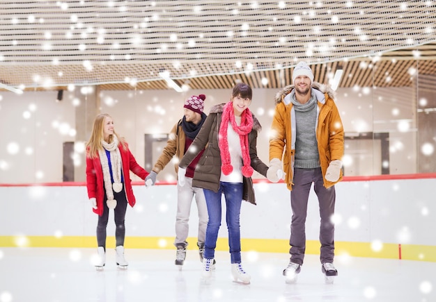 concepto de personas, amistad, deporte y ocio - amigos felices en la pista de patinaje