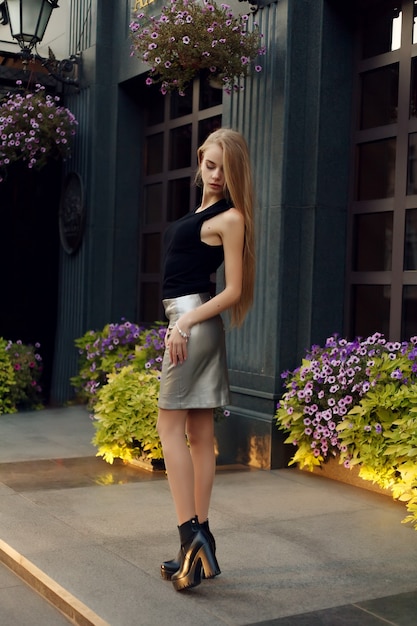 Concepto de personas, belleza, moda, estilo de vida y color - retrato de cuerpo entero al aire libre de joven hermosa niña sonriente feliz posando en la calle. Modelo mirando a cámara. Dama con ropa elegante