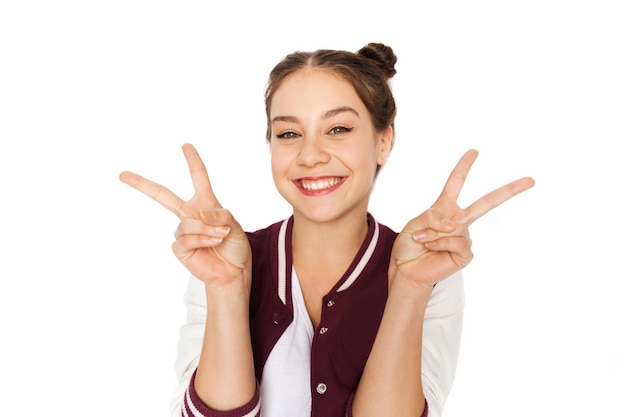 Foto concepto de personas, gestos y adolescentes - feliz sonriente linda adolescente mostrando el signo de la paz