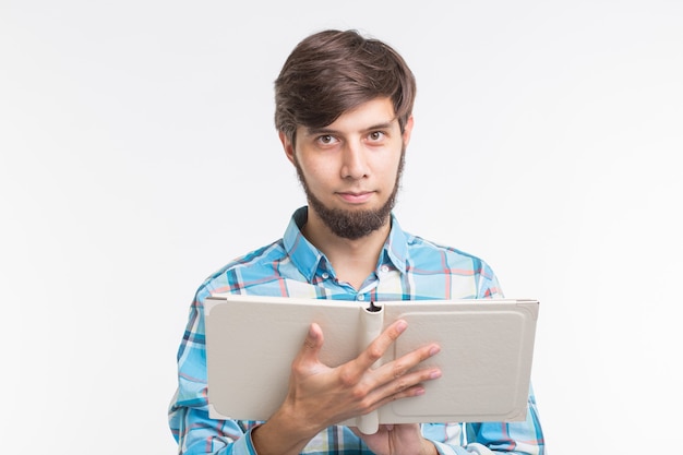 Concepto de personas, lectura y educación - joven leyendo un libro sobre fondo blanco.