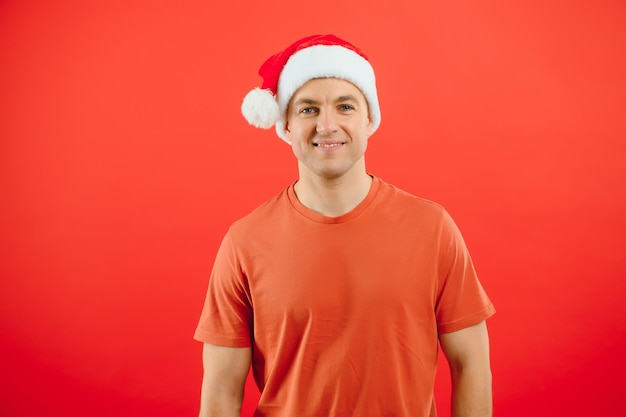 Concepto personas, lenguaje corporal, aprobación, recomendación.un hombre emocionado sombrero de Santa Claus aislado sobre fondo rojo de estudio con espacio para texto