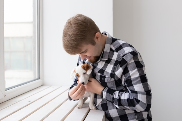 Concepto de personas, mascotas y perros - Hombre sonriente con cachorro Jack Russell Terrier.