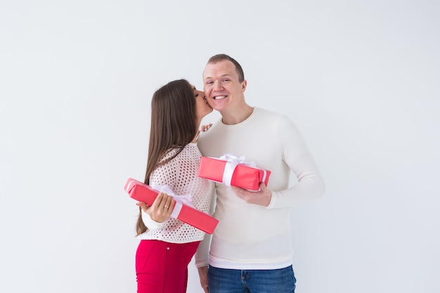 Concepto de personas, Navidad, cumpleaños, vacaciones y día de San Valentín - feliz joven y mujer con cajas de regalo sobre fondo blanco con espacio de copia.