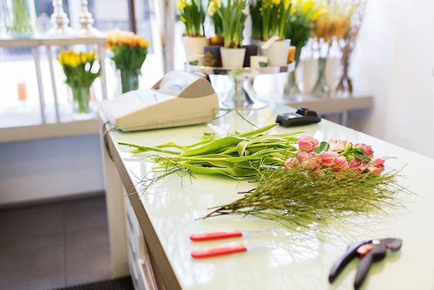 concepto de personas, negocios, venta y floristería - cierre de herramientas florísticas en el mostrador de la floristería