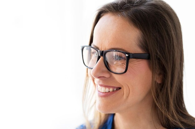 concepto de personas, oficina y visión - primer plano de una mujer de mediana edad sonriente y feliz con gafas