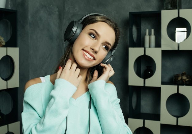 Concepto de personas y tecnología mujer feliz en auriculares escuchando música desde el teléfono inteligente