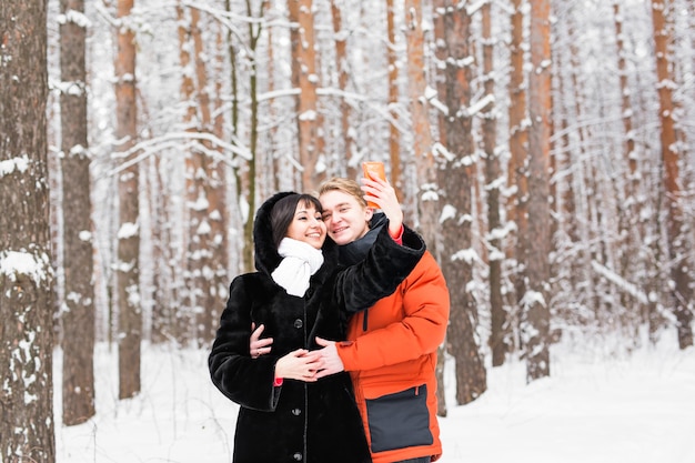 Concepto de personas, temporada, amor, tecnología y ocio. feliz pareja tomando fotos