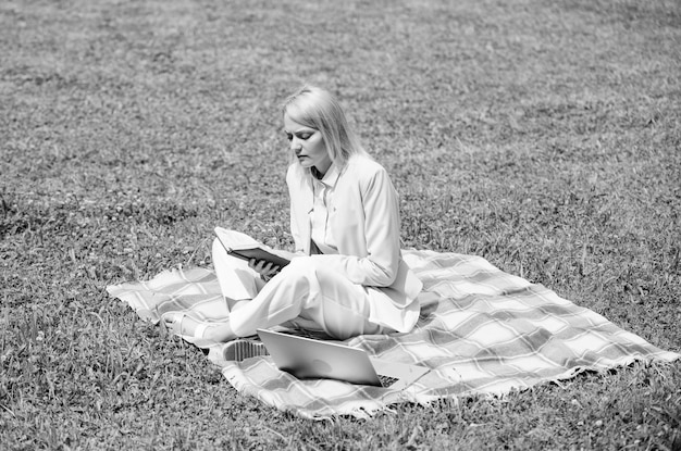 Concepto de picnic de negocios Pasos para comenzar un negocio independiente Mujer de negocios independiente trabaja al aire libre Concepto de ideas de negocios en línea Mujer con computadora portátil o portátil sentada en una alfombra pradera de hierba verde