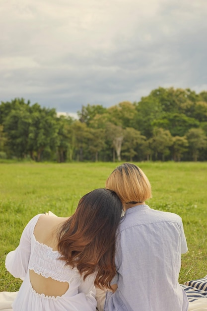 Foto concepto de picnic la parte de atrás de la pareja pasando un rato relajante descansando en el suelo del campo