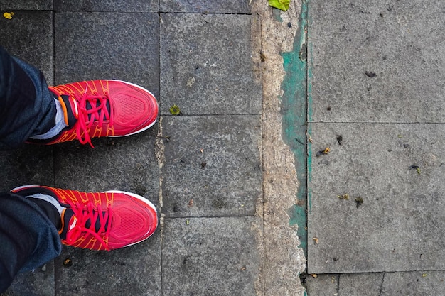 Concepto de pies en zapatos rojos sobre fondo de suelo de baldosas con espacio para texto o símbolo