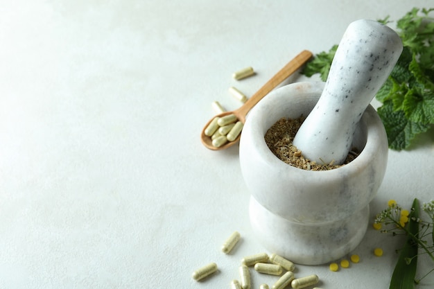 Foto concepto de píldoras de hierbas medicinales en blanco con textura