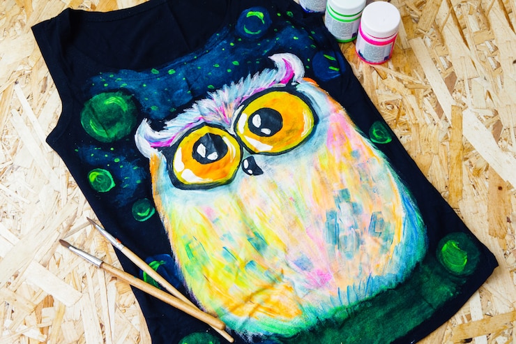 Foto concepto de pintura. un búho pintado en una camiseta negra.