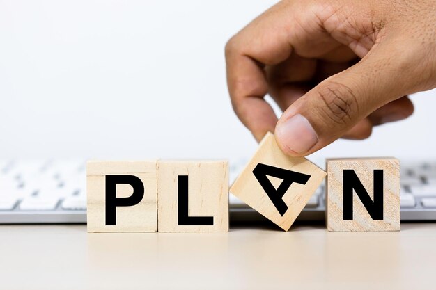 Foto concepto de planificación cubo de madera con texto plan en la mesa teclado fondo de la computadora un buen líder debe tener un plan estratégico