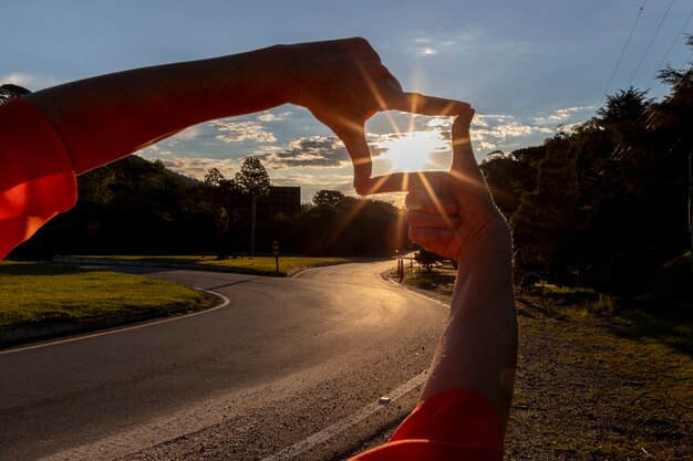 Foto concepto de planificación futura, primer plano de manos de mujer haciendo gesto de marco con puesta de sol.