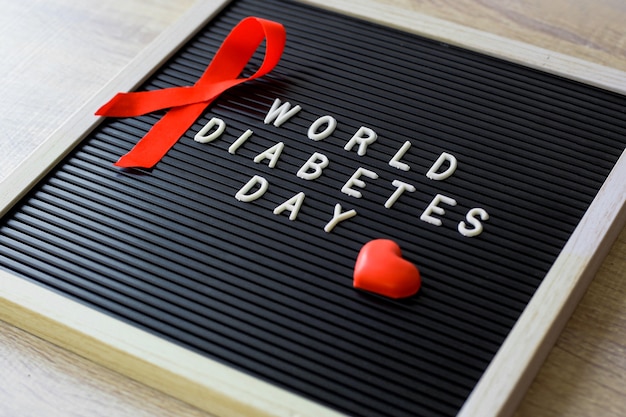 Concepto plano creativo del Día Mundial de la Diabetes con cinta roja símbolo de sangre drogas y jeringa