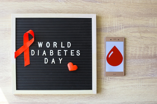 Concepto plano creativo del Día Mundial de la Diabetes con cinta roja símbolo de sangre drogas y jeringa