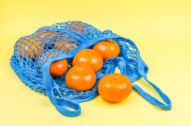 Concepto sin plástico. naranjas en una bolsa de malla azul. plástico libre