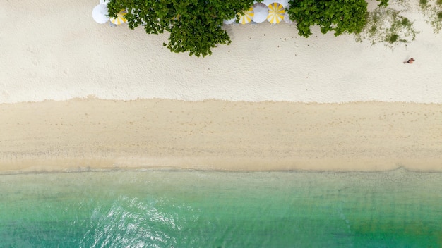 Concepto de playa natural vacaciones de verano Naturaleza de la playa de verano tropical Paraguas a bordo de un bote y un bote en la playa de arena y turismo Feliz por jugar en la arena