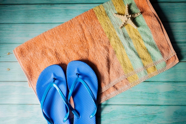 Concepto de playa para tomar el sol en verano: toalla, chanclas