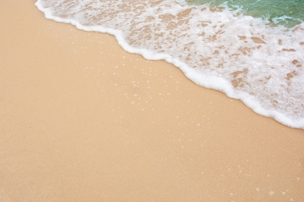 Concepto de playa de verano: suave ola de mar en la pared vacía de la playa de arena con espacio de copia
