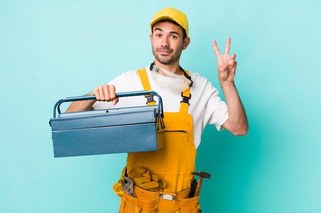 Concepto de plomero y caja de herramientas de hombre adulto joven