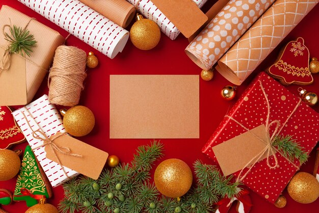 Concepto de preparaciones navideñas con papel de regalo, cajas de regalo sobre fondo rojo con espacio de copia