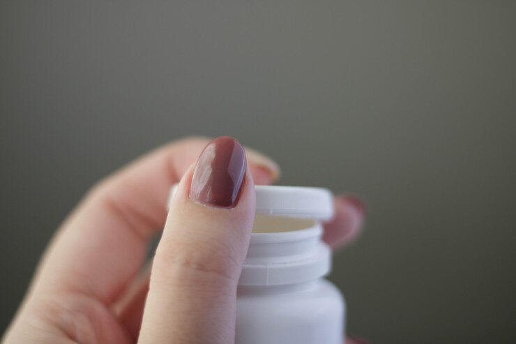 Foto concepto de prevención de enfermedades virales. la mano femenina sostiene un frasco con vitaminas, pastillas, medicamentos o drogas en